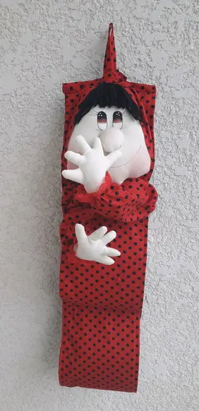 Boneca mão no nariz porta papel higiênico