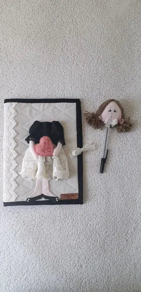 Capa de caderno com ponteira boneca