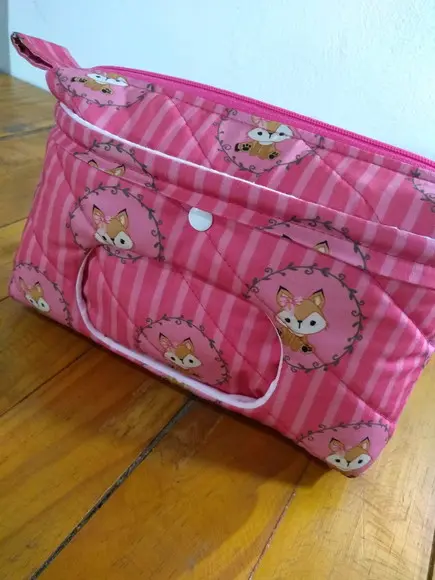 Porta lenço umedecido, fraldas e pomada.