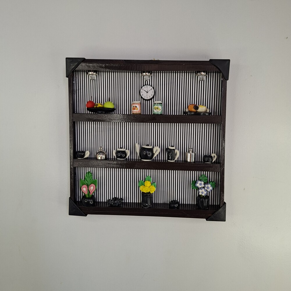 Quadro de ferro preto com fundo listrado decorado com miniaturas