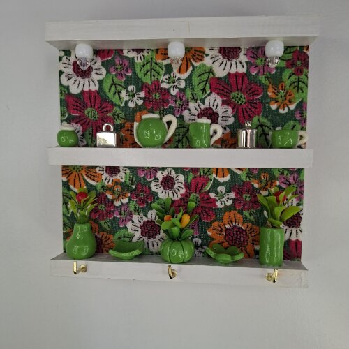 Porta chave de madeira forrado com chita verde e decorado com miniatura
