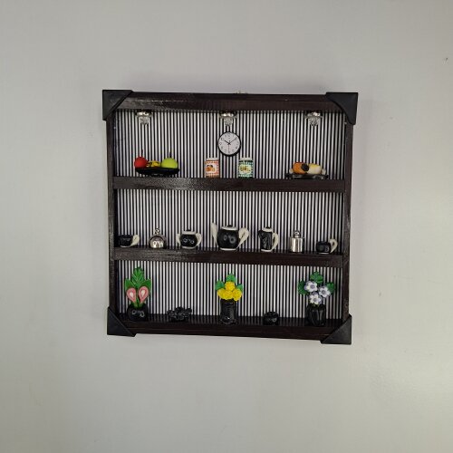 Quadro de ferro preto com fundo listrado decorado com miniaturas