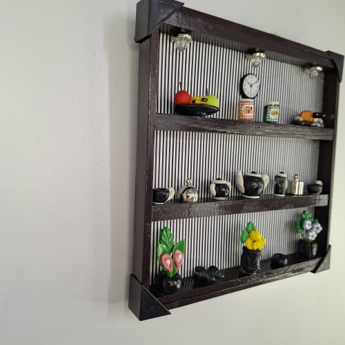 Quadro de ferro preto com fundo listrado decorado com miniaturas