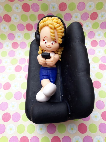 Topo de bolo, menina no sofá.