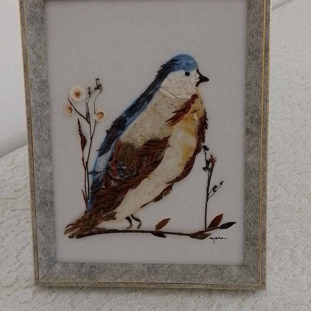 Quadro feito de de folhas e vitrilhos retratando Passarinho