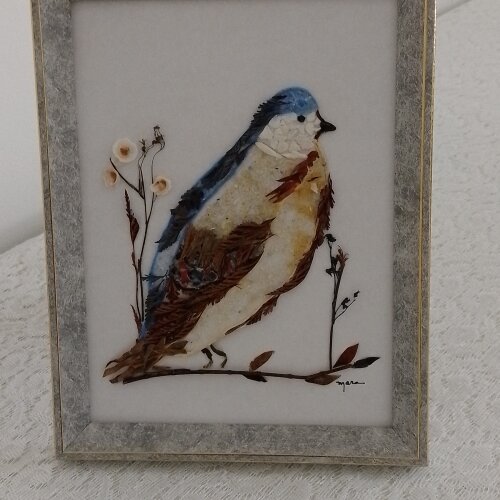 Quadro feito de de folhas e vitrilhos retratando Passarinho