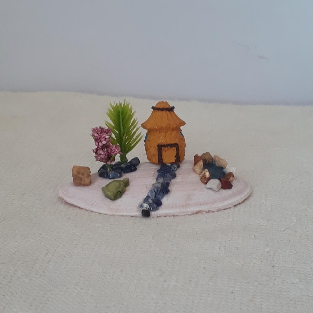 cenário com concha, casa miniatura de resina, pedras naturais e