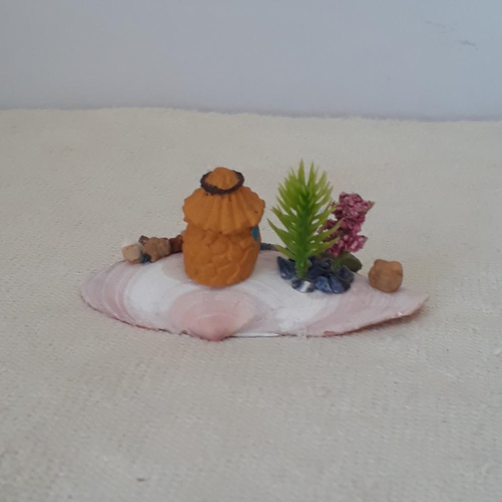 cenário com concha, casa miniatura de resina, pedras naturais e