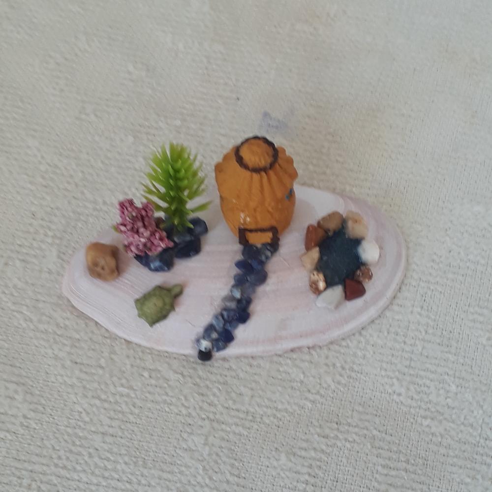 cenário com concha, casa miniatura de resina, pedras naturais e