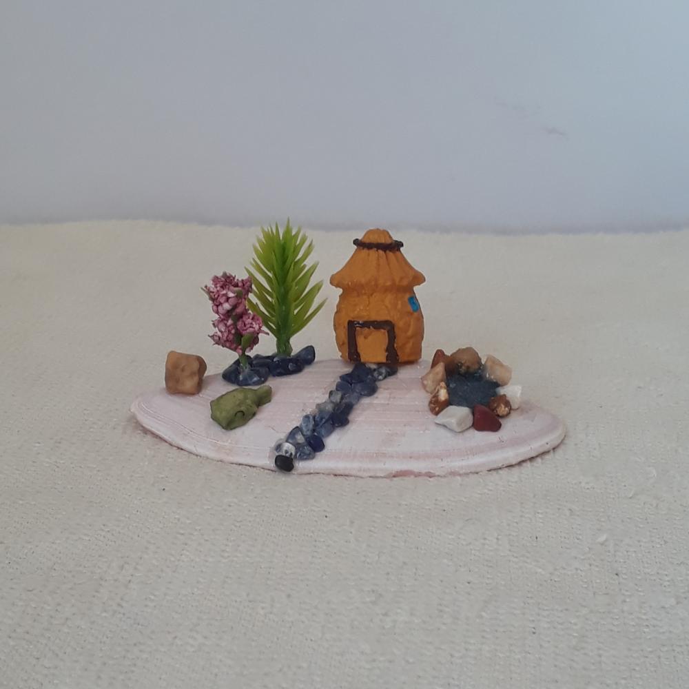 cenário com concha, casa miniatura de resina, pedras naturais e