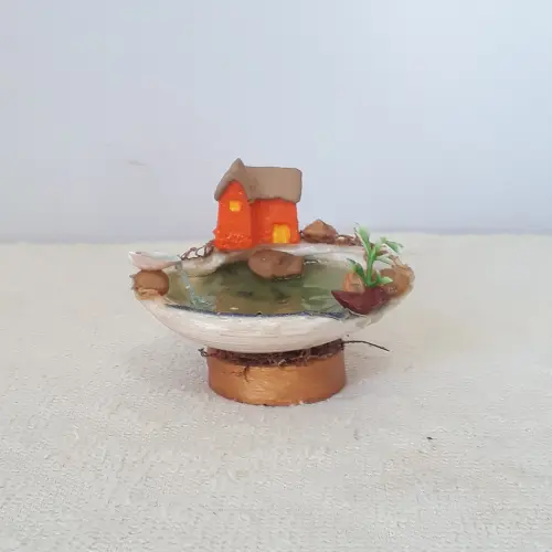 Cenário com concha e miniatura de caa de resina