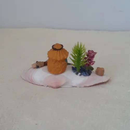 cenário com concha, casa miniatura de resina, pedras naturais e