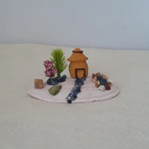 cenário com concha, casa miniatura de resina, pedras naturais e