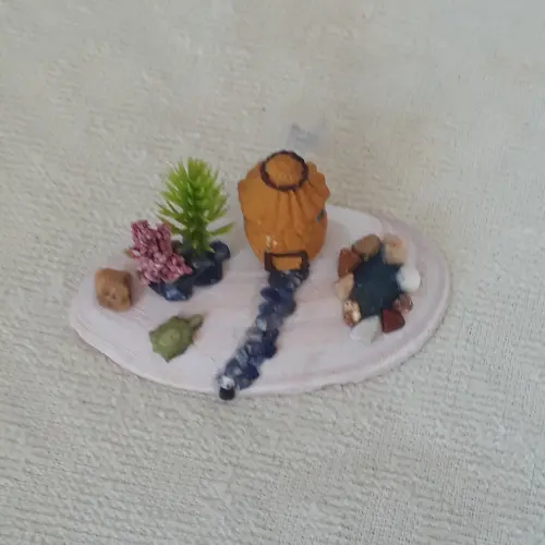 cenário com concha, casa miniatura de resina, pedras naturais e
