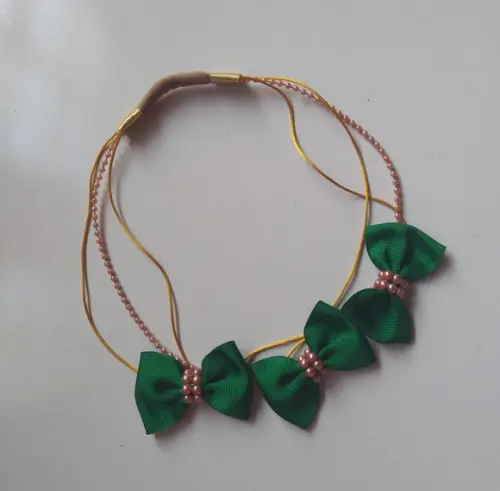 Faixinha de luxo dourado com lacinhos verdes